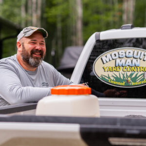 Jeff, owner of Mosquito Man, leaning against his service truck with company logo visible.